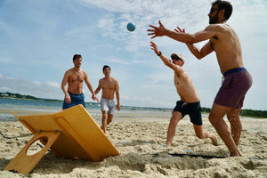 Hunnyball being played on a beach by four people